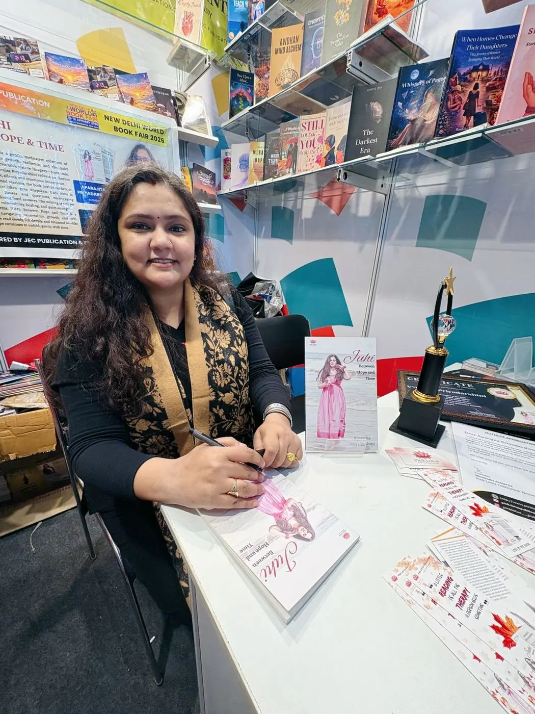 World Book Fair 2026 — author Aparajita Priyadarshini signing copies at the Pink Lotus stall